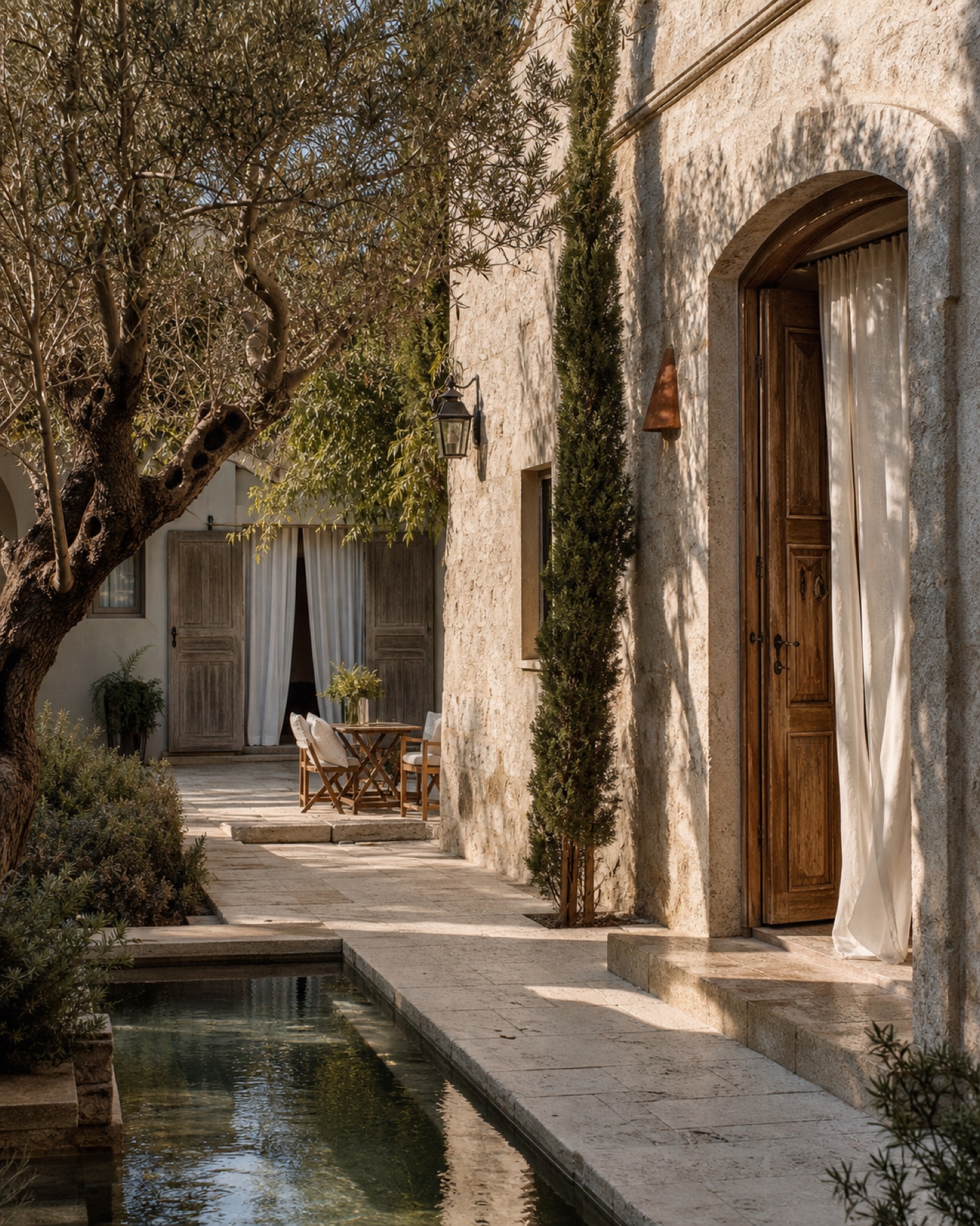 Luma House taş avlusu, zeytin ağacı ve su kanalı